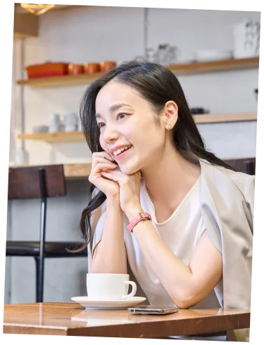 カフェで時計ベルトを身につけて微笑む女性